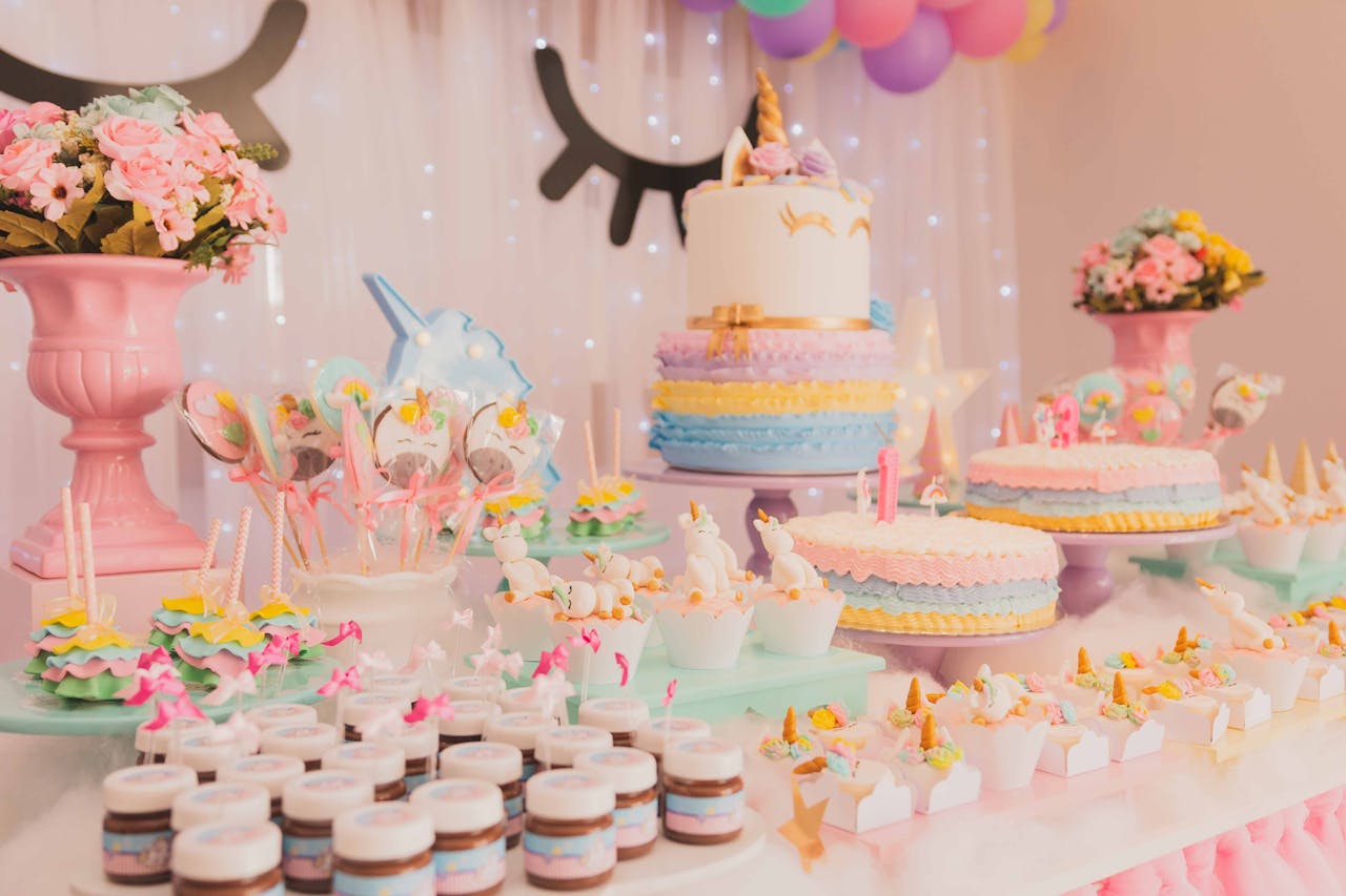 service-04 A vibrant unicorn-themed birthday party setup with cakes, cupcakes, and decorations.